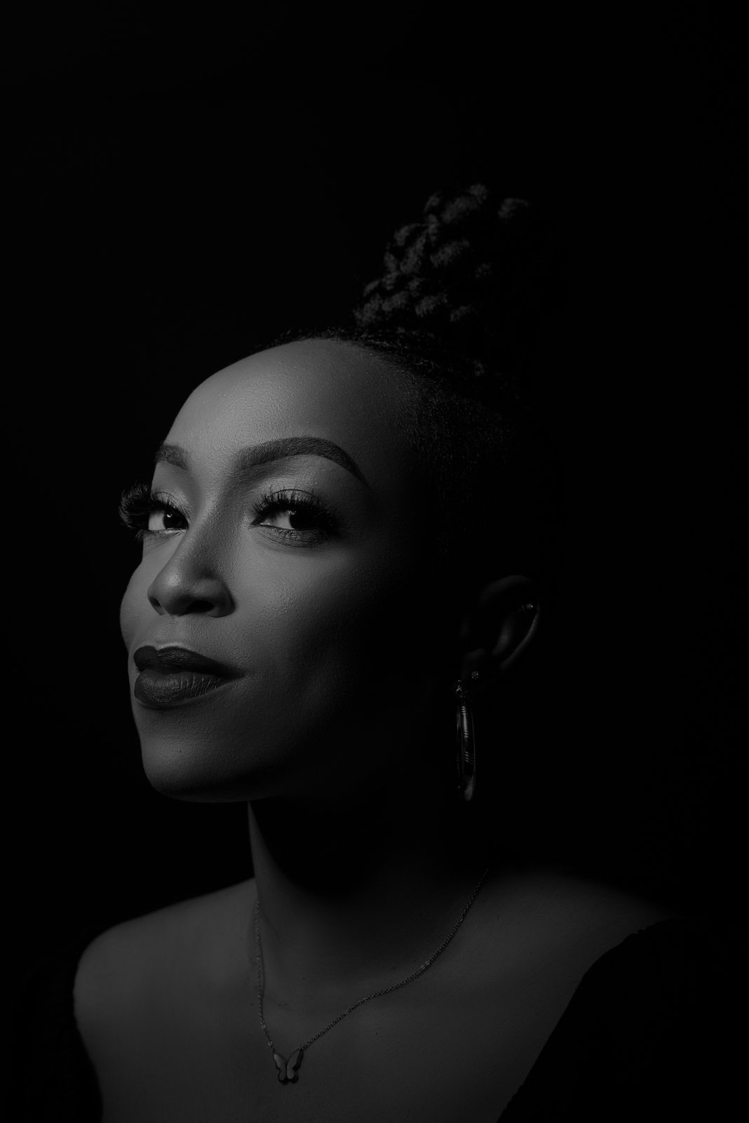 Black and white close-up portrait of Eki Ogunbor looking upward